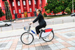 © Vadim Pastuh - Use green transport. Young woman office employee is riding a bicycle at a city street to work place
