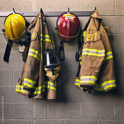 Fototapeta Firefighter helmet and protection coat hanging in the fire station