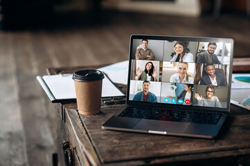 App for remote communication. Virtual meeting online. Video conference by laptop. Online business meeting. On the laptop screen, people who gathered in a video conference to work on-line