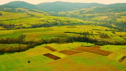 Aufkleber - drone flies above agricultural fields rural scene in spring season on the background mountains silhouette