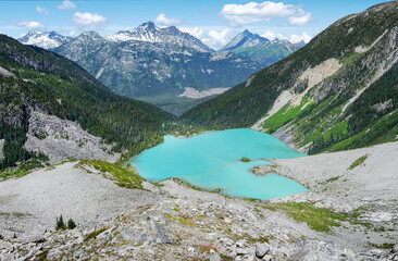 Wall Mural - Alpine turquoise glacial Upper Joffre Lake in a valley between the mountains on a sunny summer day. View from above. Amazing color of glacial water. Snow-capped mountain tops in the background. Canada