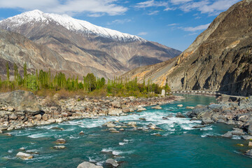  Beautiful Ghizer river and wooden suspension bridge surrounded by Hindu Gush mountains range, Gilgit Baltistan, Pakistan
