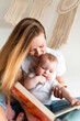 © speed300 - A young woman reads a book to her little, cute, beautiful daughter