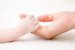 © fotoduets - Baby hand clinging young mother fingers. Closeup. Lovely, emotional, sentimental moment. Family concept.