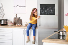 Little Girl Opening Refrigerator In Kitchen