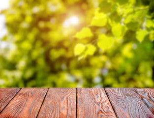 Wooden table and blurred green natural background.