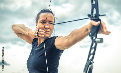 Fotografía attractive woman on archery, focuses eye target for arrow from bow