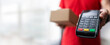 delivery payment - courier with parcel and pos terminal in hand with copy space