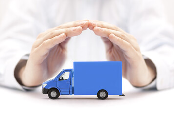 Wall Mural - Blue cargo delivery truck protected by hands