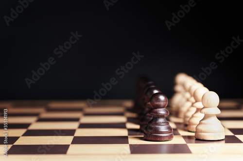 Closeup, Rows of black pawns and white pawns line up against in confrontation on chessboard. Black Lives Matter movement, human rights, stop racism, racial discrimination concept.