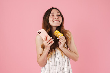 Canvas Print - Image of pleased nice woman holding cellphone and credit card