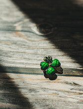 Brooch In The Form Of An Emerald Clover. St.Patrick 's Day. Wood Background.