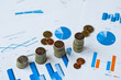 © yana_novak22 - Concept of financial economic data growth -- office supplies such as coins and abacus placed on financial data statements