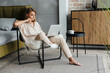 © Drobot Dean - Image of nice woman working with laptop while sitting on armchair