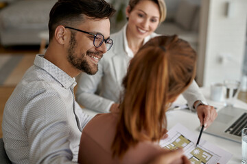 Canvas Print - Happy man and his wife having a meeting with real estate agent in the office.