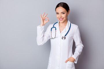 Poster - Photo of beautiful cheerful family experienced doc tell patient good news covid test negative result fingers okey symbol wear long medical uniform stethoscope isolated grey background