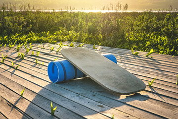 balance board on a wooden deck with sky and grass background at sunset summer day. Balance and outdoor concept