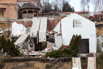 Wall Mural - Landslide caused by rains of hurricane destroyed expensive cottages and houses. Destroyed house, cottage, large cracks, chips, slabs. Broken asphalt shifted landslide after earthquake. View from drone