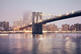 Fototapeta  - Brooklyn Bridge on a foggy night, color toned picture, New York City, USA.