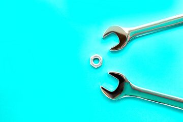 two spanners and one nut on a blue background