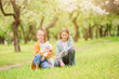 © travnikovstudio - Little smiling girls playing and hugging puppy in the park