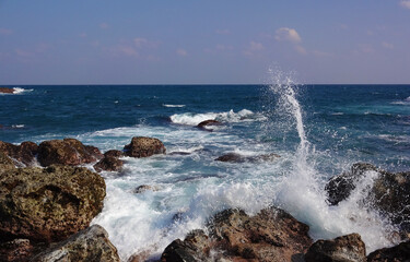 White waves rise after hitting the rocks in ocean