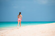 © travnikovstudio - Fit young woman doing exercises on tropical white beach in her sportswear