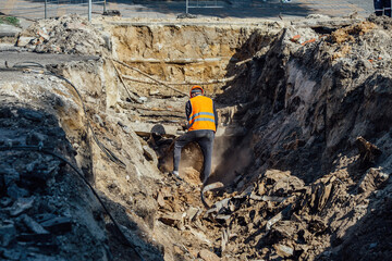 Man examining an excavation of old broken water supply or sewer pipeline