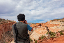 Photographer Taking Picture Of The Beautiful Cassidy Arch Of Capitol Reef National Park