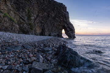 Wall Mural - Water splashing against a stone on the shore of Lake Baikal