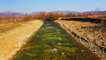 Poster - drone flies above stream pebble riverside on the background mountains landscape autumn season