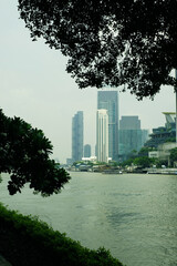 Canvas Print - View of buildings and the river within tree frame