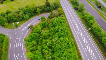 Wall Mural - drone flying above road in europe cars enter the tunnel top view on carriageway suburb