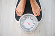 © Pixel-Shot - Young woman measuring her weight at home