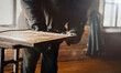© velimir - woodwork, a grinder cuts old paint and varnish from a solid wood board. furniture restoration.