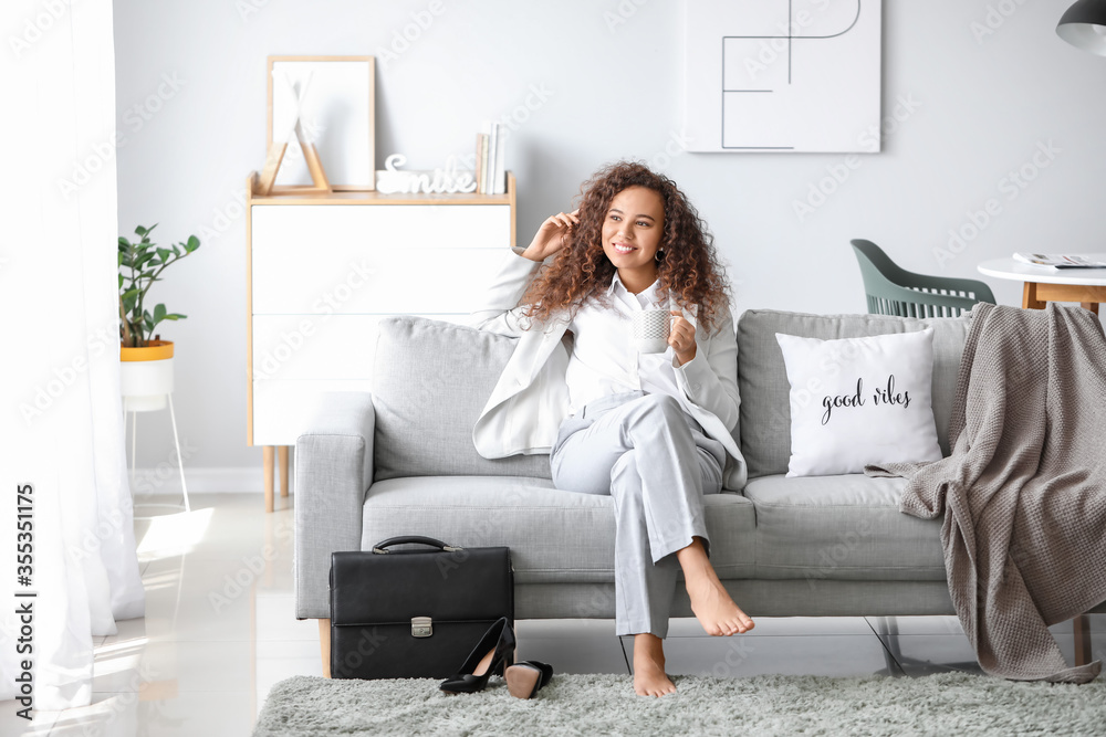 Businesswoman relaxing on sofa after work at home