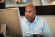 © digitalskillet1 - Mature African American man working from his home office.
