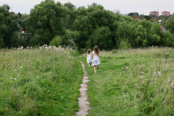 children run away along the path in the park, the concept of summer and childhood, child safety.