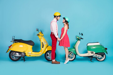 Wall Mural - Full size profile side photo positive romantic gentle wife husband bikers hold hand enjoy motor bike honeymoon stand choppers wear red dotted dress shirt pants isolated blue color background