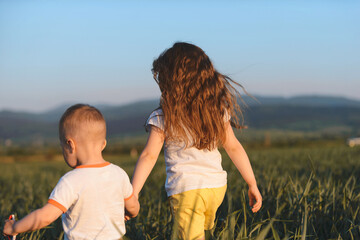 Poster - sister and brother holding hands in field