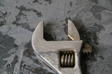 Old wrench adjustable wrench close-up on a dark gray background with place for text