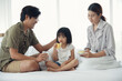 © Pruksachat - Happy Asian family having breakfast with milk bread sausages at bedroom, a little daughter eating sausage bread on bed at home