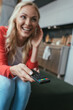 © LIGHTFIELD STUDIOS - selective focus of excited woman laughing while watching tv at home