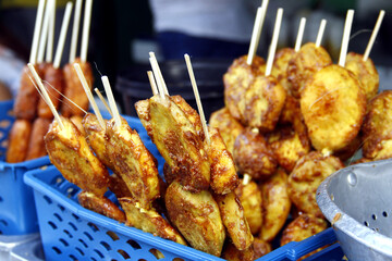 Wall Mural - Filipino snack food called Kamote Cue or deep fried sweet potato with brown sugar in barbecue sticks