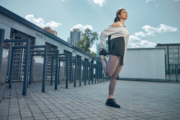 Sporty Caucasian woman doing a quad stretch