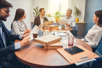 Wall Mural - Happy young colleagues discussing new contract with male boss