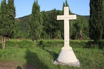 Withe marble cross against blue cloudy sky in Italy