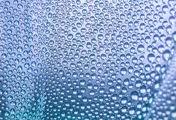 Close up water drops on light lilac tone background. Abstract light lilac wet texture with water drops on glass surface. Selective focus