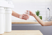 Female Hand Giving A Glass Of Clean Water. Purified Water And Healthy Life Concept.
