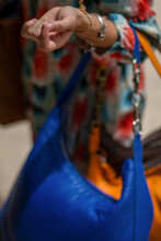 Close Up Of Cool Girl With Fancy Multi Coloured Dress Carrying Several Expensive Leather Bags.